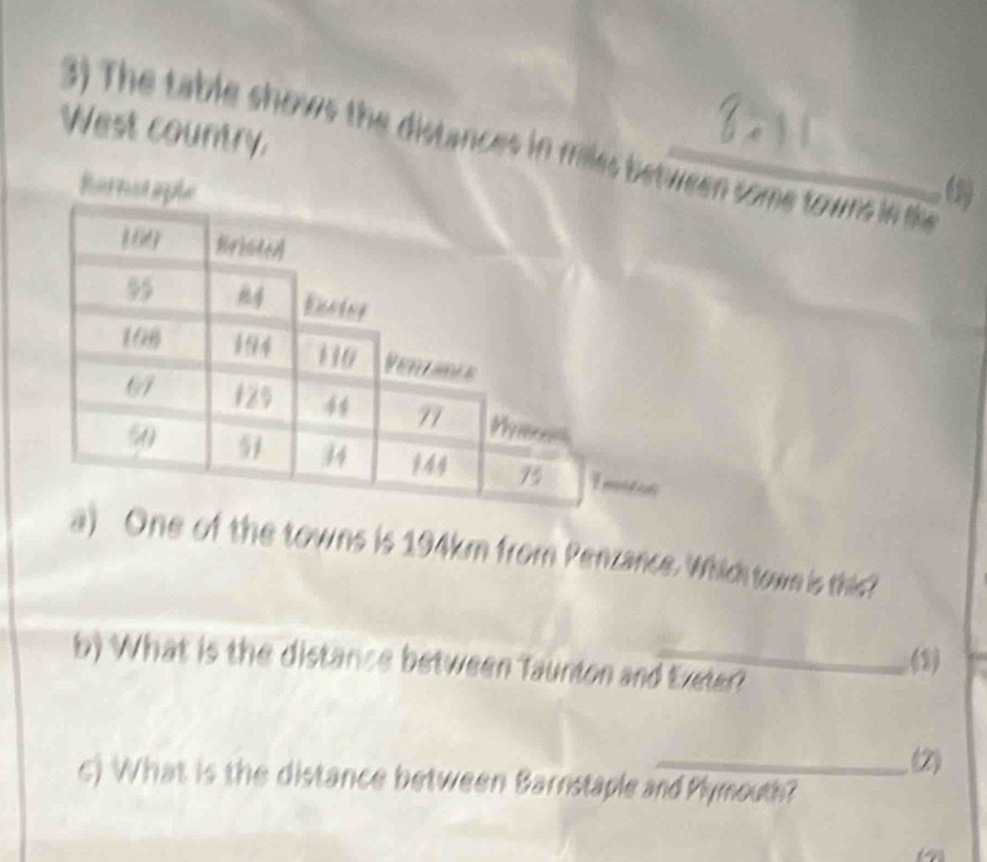 West country. 
3) The table shows the distances in miles between some towns in the 
harno6 
a) One of the towns is 194km from Penzance. Which town is this? 
b) What is the distance between Taunton and Exeter? 
(2) 
(2) 
c) What is the distance between Barnstaple and Plymouth? 
a