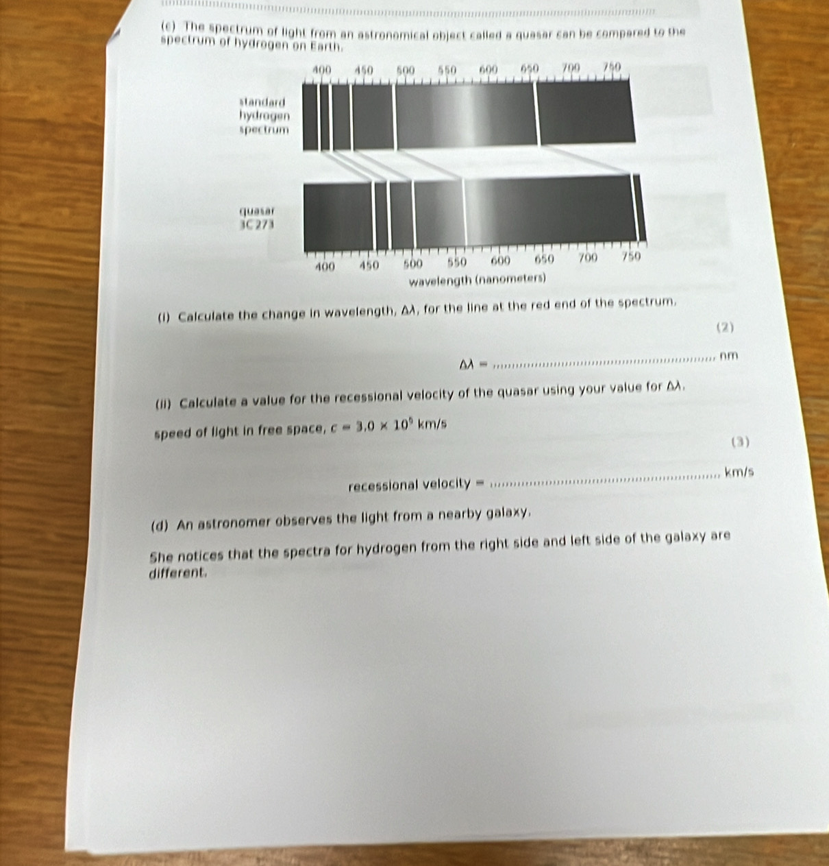 The spectrum of light from an astronomical object called a quasar can be compared to the 
spectrum of hydrogen on Earth. 
(I) Calculate the change in wavelength, Δλ, for the line at the red end of the spectrum. 
(2)
△ lambda =
_ n m
(ii) Calculate a value for the recessional velocity of the quasar using your value for Δλ. 
speed of light in free space, c=3.0* 10^5km/s
(3) 
_ km/s
recessional velocity = 
(d) An astronomer observes the light from a nearby galaxy. 
She notices that the spectra for hydrogen from the right side and left side of the galaxy are 
different.