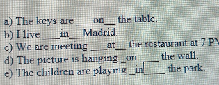 The keys are _on_ the table. 
b) I live _in_ Madrid. 
c) We are meeting _at_ the restaurant at 7 PN 
d) The picture is hanging _on_ the wall. 
e) The children are playing _in_ the park.