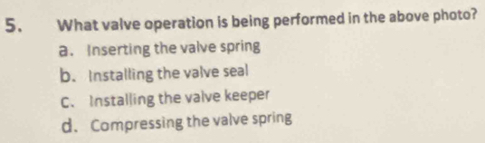 What valve operation is being performed in the above photo?
a. Inserting the valve spring
b. Installing the valve seal
C. Installing the valve keeper
d.Compressing the valve spring