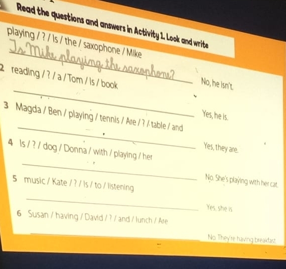 Read the questions and answers in Activity 1. Look and write 
_ 
playing / ? / ls / the / saxophone / Mike 
_ 
2 reading / ? / a / Tom / Is / book 
No, he isn't. 
Yes, he is. 
_ 
3 Magda / Ben / playing / tennis / Are / ? / table / and 
Yes, they are. 
_ 
4 ls / ? / dog / Donna / with / playing / her 
No. She's playing with her cat. 
5 music / Kate / ? / Is / to / listening 
_ 
Yes, she is 
6 Susan / having / David / ? / and / lunch / Are 
_ 
No. They're having breakfast.