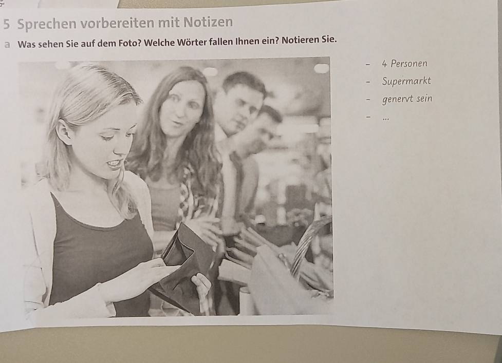 Sprechen vorbereiten mit Notizen 
a Was sehen Sie auf dem Foto? Welche Wörter fallen Ihnen ein? Notieren Sie.
- 4 Personen 
- Supermarkt 
- genervt sein 
….