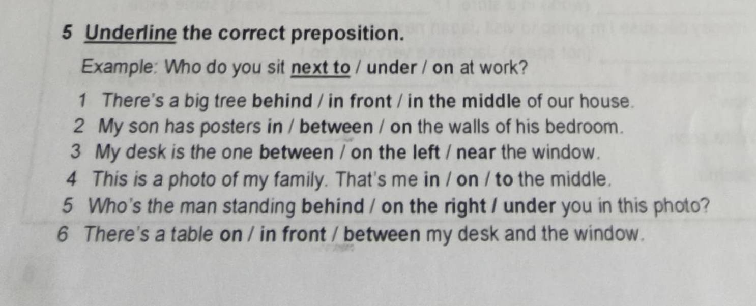 Underline the correct preposition. 
Example: Who do you sit next to / under / on at work? 
1 There's a big tree behind / in front / in the middle of our house. 
2 My son has posters in / between / on the walls of his bedroom. 
3 My desk is the one between / on the left / near the window. 
4 This is a photo of my family. That's me in / on / to the middle. 
5 Who's the man standing behind / on the right / under you in this photo? 
6 There's a table on / in front / between my desk and the window.