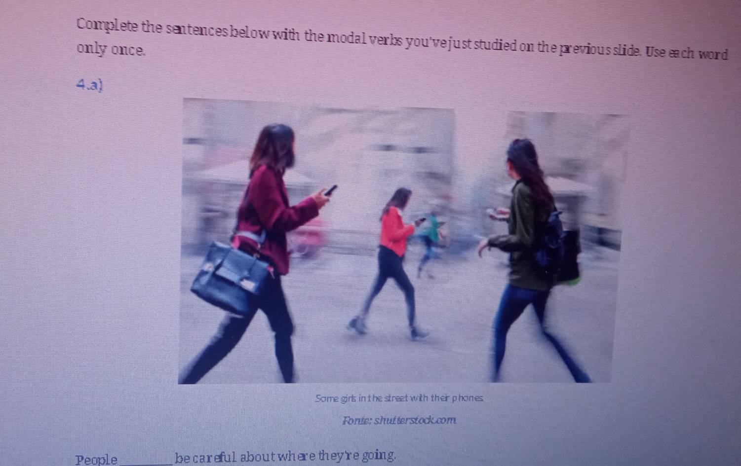 Complete the sentences below with the modal verbs you've just studied on the previous slide. Use each word 
only once. 
4.a) 
Some girls in the street with their phones 
Fonie: shutterstock.com 
People _be careful about where they're going.