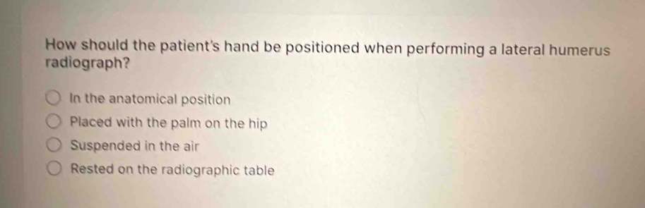 How should the patient's hand be positioned when performing a lateral humerus
radiograph?
In the anatomical position
Placed with the palm on the hip
Suspended in the air
Rested on the radiographic table