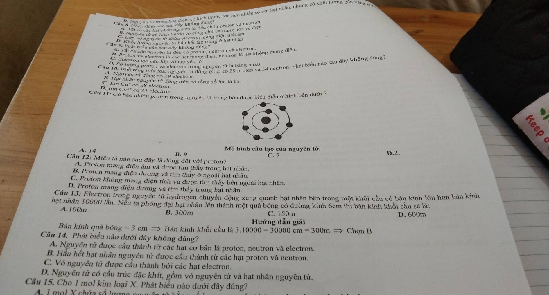 D. Nguyên tử trung hòa điện, có kích thước lớn hơn nhiều so với hạt nhân, nhưng có khối lượng gân bằng kho
Câu 8. Nhân định nào sau đây không đúng?
A. Tất cả các hạt nhân nguyên tử đều chứa proton và neutron
B. Nguyên tử có kích thước vô cùng nhỏ và trung hòa về điện
C. Lớp vỏ nguyên tử chứa electron mang điện tích âm
D. Khối lượng nguyên tử hầu hết tập trung ở hạt nhân
Câu 9. Phát biểu nào sau đây không đúng?
A. Tất cả các nguyên tử đều có proton, neutron và electron
B. Proton và electron là các hạt mang điện, neutron là hạt không mang điện
C. Electron tạo nên lớp vỏ nguyên tử.
Câu 10. Biết rằng một loại nguyên tử đồng (Cu) ) có 29 proton và 34 neutron. Phát biều nào sau đây không đúng?
D. Số lượng proton và electron trong nguyên tử là bằng nhau
A. Nguyên tử đồng có 29 electron
B. Hạt nhân nguyên tử đồng trên có tổng số hạt là 63.
C. Ion Cu * có 28 electron
D. Ion Cu²  có 31 electron.
Câu 11: Có bao nhiêu proton trong nguyên tử trung hòa được biểu diễn ở hình bên dưới ?
:
C
A. 14
Mô hình cấu tạo của nguyên tử.
B. 9 C. 7 D.2.
Câu 12: Miêu tả nào sau đây là đúng đối với proton?
A. Proton mang điện âm và được tìm thấy trong hạt nhân.
B. Proton mang điện dương và tìm thấy ở ngoài hạt nhân.
C. Proton không mang điện tích và được tìm thấy bên ngoài hạt nhân.
D. Proton mang điện dương và tìm thấy trong hạt nhân.
Câu 13: Electron trong nguyên tử hydrogen chuyển động xung quanh hạt nhân bên trong một khối cầu có bán kính lớn hơn bán kính
hạt nhân 10000 lần. Nếu ta phóng đại hạt nhân lên thành một quả bóng có đường kính 6cm thì bán kính khối cầu sẽ là:
A.100m B. 300m C. 150m D. 600m
Hướng dẫn giải
Bán kính quả bóng =3cm I to Bán kính khối cầu là 3.10000=30000cm=300mRightarrow Chọn B
Câu 14. Phát biểu nào dưới đây không đúng?
A. Nguyên tử được cấu thành từ các hạt cơ bản là proton, neutron và electron.
B. Hầu hết hạt nhân nguyên tử được cấu thành từ các hạt proton và neutron.
C. Vỏ nguyên tử được cầu thành bởi các hạt electron.
D. Nguyên tử có cấu trúc đặc khít, gồm vỏ nguyên tử và hạt nhân nguyên tử.
Câu 15. Cho 1 mol kim loại X. Phát biểu nào dưới đây đúng?
1           ứ a  s  lượ