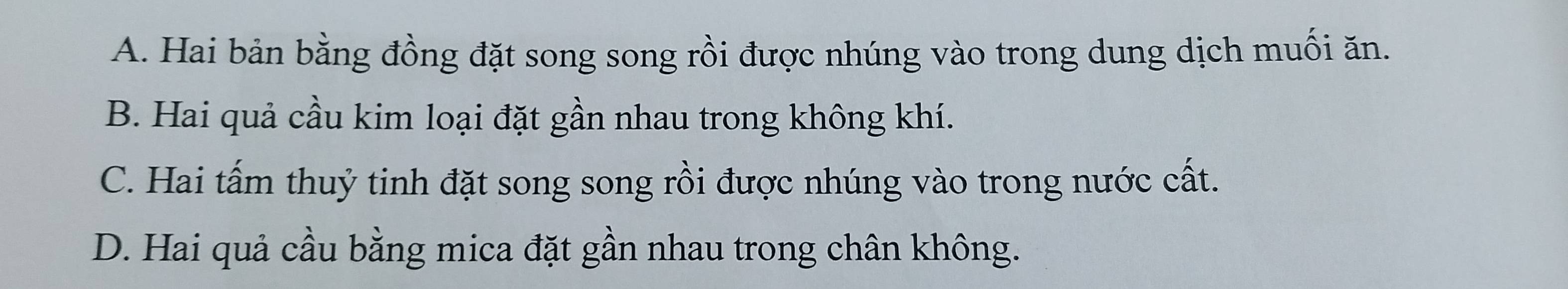 A. Hai bản bằng đồng đặt song song rồi được nhúng vào trong dung dịch muối ăn.
B. Hai quả cầu kim loại đặt gần nhau trong không khí.
C. Hai tấm thuỷ tinh đặt song song rồi được nhúng vào trong nước cất.
D. Hai quả cầu bằng mica đặt gần nhau trong chân không.