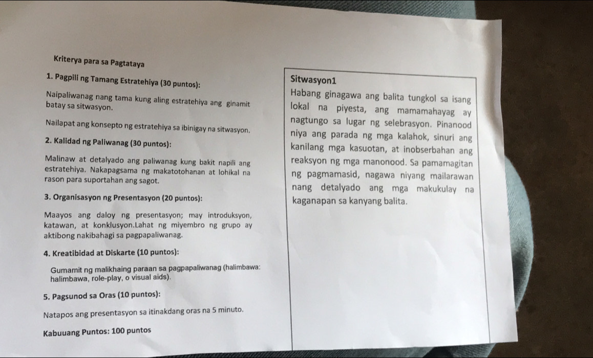 Kriterya para sa Pagtataya 
Sitwasyon1 
1. Pagpili ng Tamang Estratehiya (30 puntos): Habang ginagawa ang balita tungkol sa isang 
Naipaliwanag nang tama kung aling estratehiya ang ginamit lokal na piyesta, ang mamamahayag ay 
batay sa sitwasyon. 
nagtungo sa lugar ng selebrasyon. Pinanood 
Nailapat ang konsepto ng estratehiya sa ibinigay na sitwasyon. niya ang parada ng mga kalahok, sinuri ang 
2. Kalidad ng Paliwanag (30 puntos): kanilang mga kasuotan, at inobserbahan ang 
Malinaw at detalyado ang paliwanag kung bakit napili ang reaksyon ng mga manonood. Sa pamamagitan 
estratehiya. Nakapagsama ng makatotohanan at lohikal na ng pagmamasid, nagawa niyang mailarawan 
rason para suportahan ang sagot. nang detalyado ang mga makukulay na 
3. Organisasyon ng Presentasyon (20 puntos): kaganapan sa kanyang balita. 
Maayos ang daloyng presentasyon; may introduksyon, 
katawan, at konklusyon.Lahat ng miyembro ng grupo ay 
aktibong nakibahagi sa pagpapaliwanag. 
4. Kreatibidad at Diskarte (10 puntos): 
Gumamit ng malikhaing paraan sa pagpapaliwanag (halimbawa: 
halimbawa, role-play, o visual aids). 
5. Pagsunod sa Oras (10 puntos): 
Natapos ang presentasyon sa itinakdang oras na 5 minuto. 
Kabuuang Puntos: 100 puntos