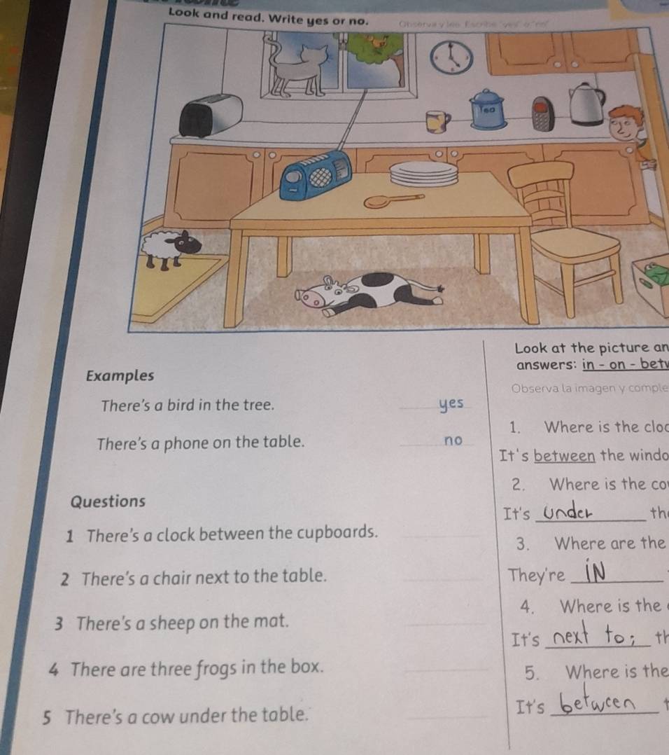 Look and read. W 
Look at the picture an 
answers: in - on - bet 
Examples 
Observa la imagen y comple 
There’s a bird in the tree. _yes 
1. Where is the cloo 
There’s a phone on the table. _no 
It's between the windo 
2. Where is the co 
Questions 
It's_ th 
1 There’s a clock between the cupboards. 
3. Where are the 
2 There’s a chair next to the table. They're_ 
4. Where is the 
3 There's a sheep on the mat. 
It's _th 
4 There are three frogs in the box. 
5. Where is the 
5 There’s a cow under the table. 
It's_