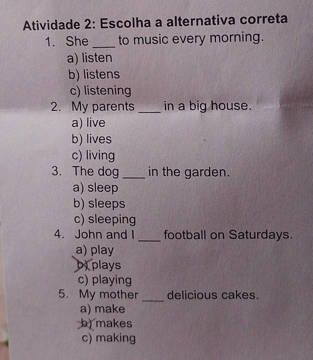 Atividade 2: Escolha a alternativa correta
1. She _to music every morning.
a) listen
b) listens
c) listening
2. My parents _in a big house.
a) live
b) lives
c) living
3. The dog _in the garden.
a) sleep
b) sleeps
c) sleeping
4. John and I _football on Saturdays.
a) play
b)plays
c) playing
5. My mother _delicious cakes.
a) make
b) makes
c) making