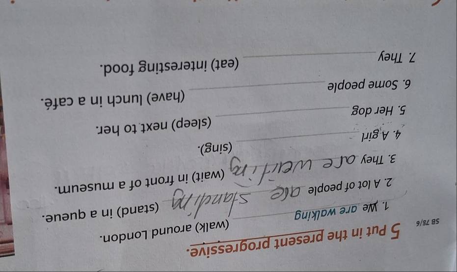 SB 78/6 5 Put in the present progressive. 
1. We are walking (walk) around London. 
2. A lot of people __(stand) in a queue. 
(wait) in front of a museum. 
3. They 
_ 
4. A girl_ (sing). 
5. Her dog_ (sleep) next to her. 
6. Some people_ (have) lunch in a café. 
7. They_ (eat) interesting food.
