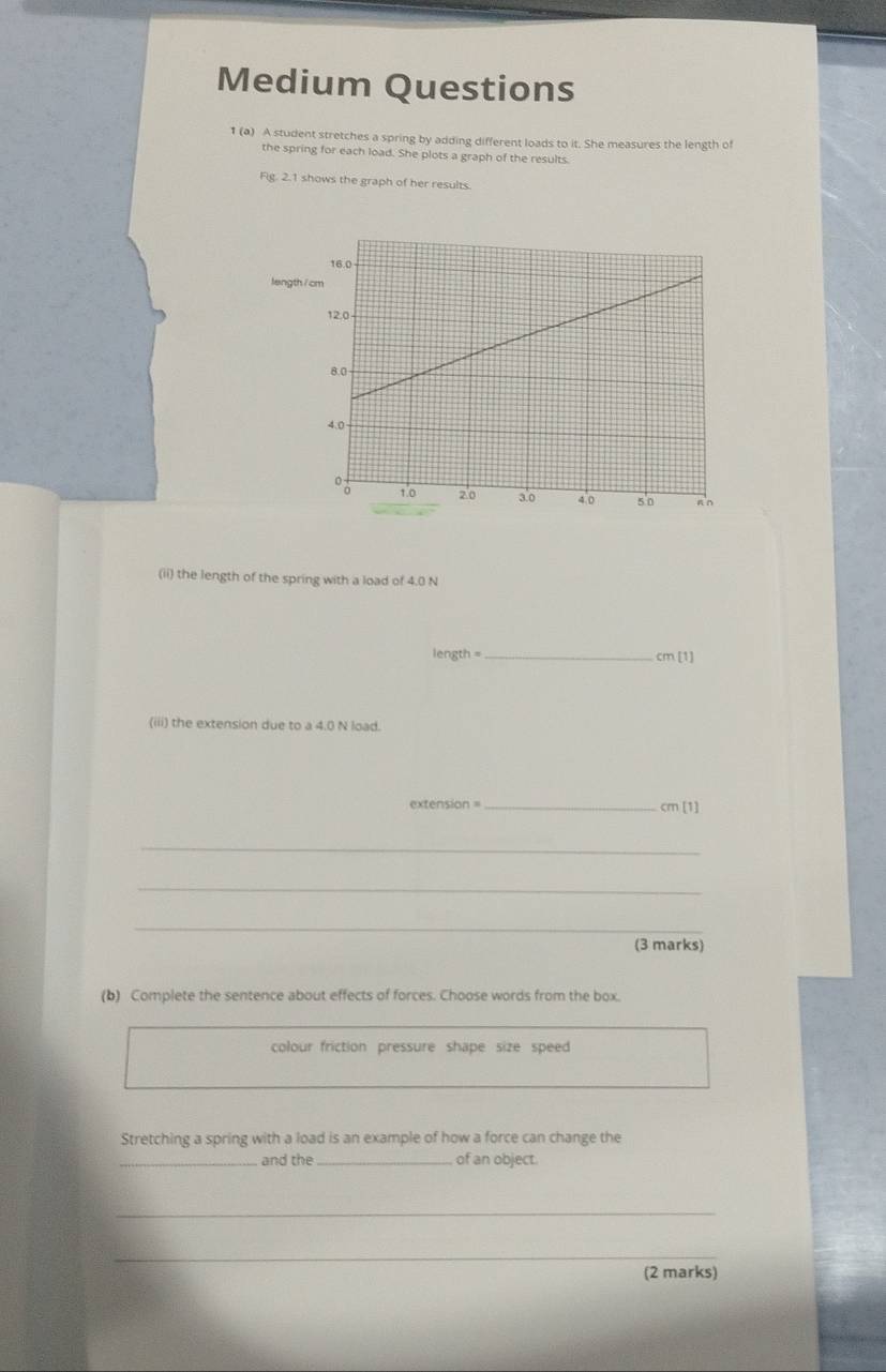 Medium Questions 
1 (a) A student stretches a spring by adding different loads to it. She measures the length of 
the spring for each load. She plots a graph of the results. 
Fig. 2.1 shows the graph of her results. 
length 
(ii) the length of the spring with a load of 4.0 N
length = _ cm[1]
(iii) the extension due to a 4.0 N load. 
extension 
_ cm[1]
_ 
_ 
_ 
(3 marks) 
(b) Complete the sentence about effects of forces. Choose words from the box. 
colour friction pressure shape size speed 
Stretching a spring with a load is an example of how a force can change the 
_and the_ of an object. 
_ 
_ 
(2 marks)