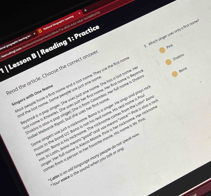 onal geographic learning inic > National Geographic Leaming 
ar.eltngL.com/dashboard/assignments/d6b4c77a-d020-4c62-b8a0-5b24fdf5d1 
Pink 
| Lesson B | Reading 1: Practic 
Shakira 
ost people have a first name and a last name. They use the first no . Which singer uses only a first name 
ead the article. Choose the correct answe 
voncé is a pop singer. She uses just one name. She has a last name. I 
Singers with One Name 
nd the last name. Some people use just one nam 
t name is Knowles. She uses just her first name. Her first name is Beyor 
Bono 
akira is also a pop singer. She is from Colombia. Her full name is Shal 
me singers use just a nickname. Bono is a singer. He sings and plays r 
abel Mebarak Ripoll, but she uses her first nam 
sic in the band U2. Bono is not his real name. His real name is P 
wson. Bono is his nickname. The nickname comes from the Latin" b 
. In Latin, bono means "good" and vox means “voice." " Pink is also a 
ger. Her full name is Alecia Moore. Pink is her nickname. Her nickno 
mes from a person in her favorite movie. His name is Mr. P 
tin is an old language many people do not speak no 
our voice is the sound when you talk or si