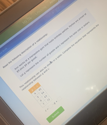 Ass 
My IXI Leamnmno 
arks at a trampoline gym that hosts birthday parties. Parties are 
d the following description of a relations epresent the number of guests and c represent the total cost in 
r bevets 
tionship can also be shown in a table. Complete the equation that repre
9 plus $9 per gues 
ationship between g and
C
45
4 54
5 63 c=□ · g+□ 72
6
7
Submit
