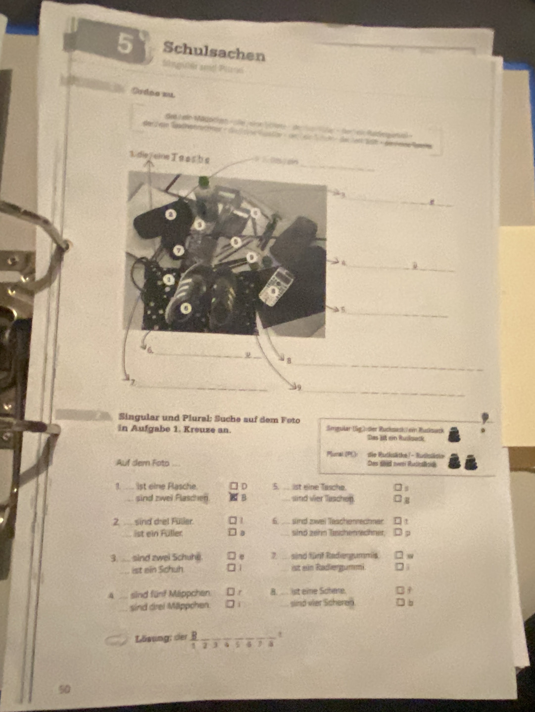 Schulsachen
Slnguler and Pirs
Ordeo zu
Sed Jeln Mädodreh- se joloe lcitete - de te ale - (te ei Raldieg ania »
1. d
__e
_D
_
ψ
_
_
_
9
Singular und Piural: Suche auf dem Foto
in Aufgabe 1. Kreuze an. Singular (Sg)) tler Rucksack ein Rudksack
Das jat ein Ruskwack.
Plumal (PU): die Rudksädke - Rudisädke
Auf dem Foto Des stid awei Rucnslnde
1. ist eine Plasche ] D 5._ ist eine Tasche.
sind zwei Flaschen B _sind vier Taschen.
2. ... sind drei Füller. 1 6. ....sind zwei Tascherrechner t
ist ein Füller. sind zehn Tæichenrechner.
3. . sind zwei Schuhe. 7 sind fünf Radergummis. )
ist ein Schuh □ 1 ist ein Radiergummi 4
4 sind fünf Mäppchen □ r 8. ist eie Schere.
sind drei Mäppchen. sind vier Scheren. ) b
Lösung: der B_ t
1
8
50