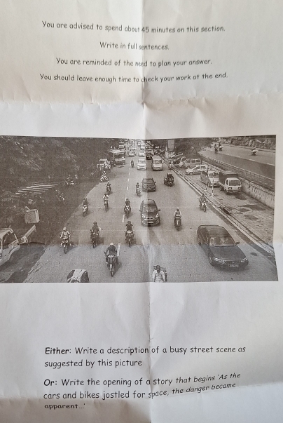You are advised to spend abou! 45 minutes on this section. 
Write in full sentences. 
You are reminded of the ned to plan your answer. 
You should leave enough time to check your work at the end. 
Either: Write a description of a busy street scene as 
suggested by this picture 
Or: Write the opening of a story that begins 'As the 
cars and bikes jostled for space, the danger became 
apparent...'