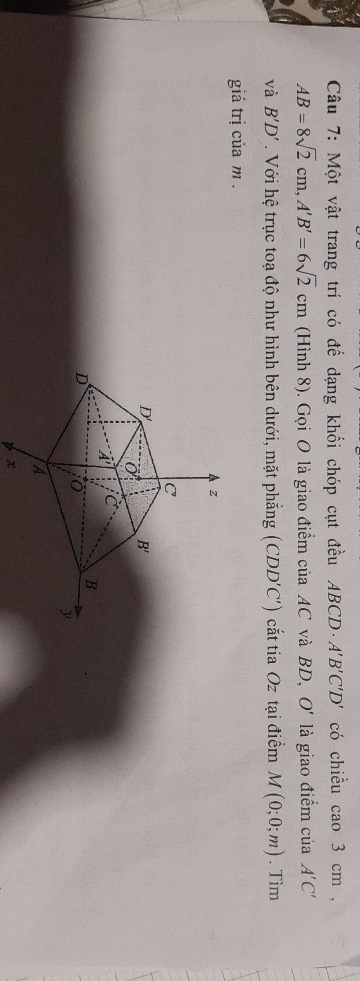 Một vật trang trí có đế dạng khối chóp cụt đều ABCD· A'B'C'D' có chiều cao 3 cm ,
AB=8sqrt(2)cm,A'B'=6sqrt(2)cm (Hình 8). Gọi O là giao điểm của AC và BD, O' là giao điểm của A'C'
và B'D'.  Với hệ trục toạ độ như hình bên dưới, mặt phẳng (CDD'C') cắt tia Oz tại điểm M(0;0;m). Tìm
giá trị của m .