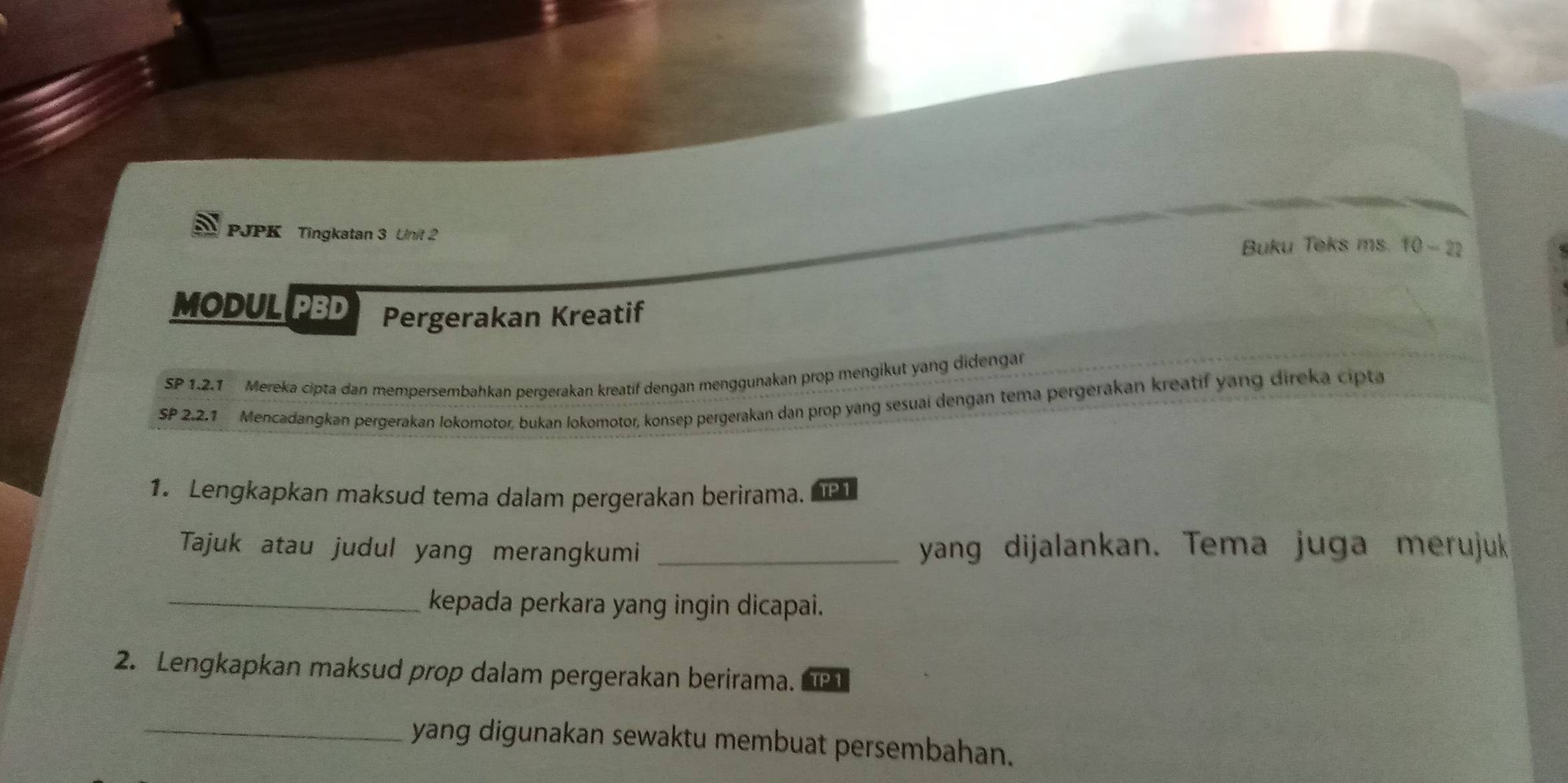 PJPK Tingkatan 3 Unit 2 
Buku Teks ms. 10-22 
MODUL PBD Pergerakan Kreatif 
SP 1.2.1 Mereka cipta dan mempersembahkan pergerakan kreatif dengan menggunakan prop mengikut yang didengan 
SP 2.2.1 Mencadangkan pergerakan lokomotor, bukan lokomotor, konsep pergerakan dan prop yang sesuai dengan tema pergerakan kreatif yang direka cipta 
1. Lengkapkan maksud tema dalam pergerakan berirama. TP1 
Tajuk atau judul yang merangkumi _yang dijalankan. Tema juga merujuk 
_kepada perkara yang ingin dicapai. 
2. Lengkapkan maksud prop dalam pergerakan berirama. 
_yang digunakan sewaktu membuat persembahan.