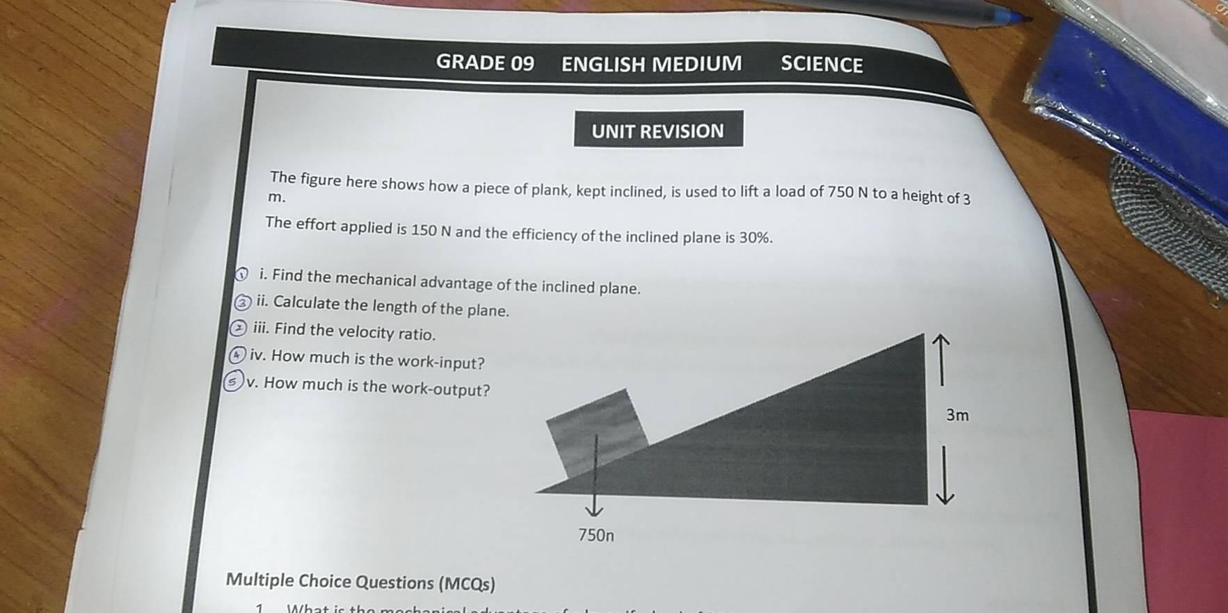 GRADE 09 ENGLISH MEDIUM SCIENCE 
UNIT REVISION 
The figure here shows how a piece of plank, kept inclined, is used to lift a load of 750 N to a height of 3
m. 
The effort applied is 150 N and the efficiency of the inclined plane is 30%. 
i. Find the mechanical advantage of the inclined plane. 
ii. Calculate the length of the plane. 
iii. Find the velocity ratio. 
iv. How much is the work-input? 
v. How much is the work-output? 
Multiple Choice Questions (MCQs)