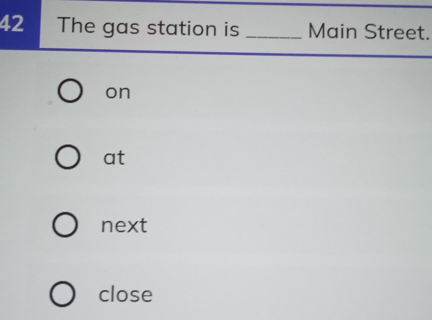 The gas station is _Main Street.
on
at
next
close