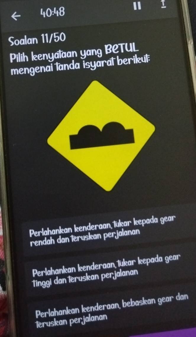 40:48
Soalan 11/50
Pilih kenyalaan yang BCTUL
mengenai tanda isyaral berikut
Perlahankan kenderaan, tükar kepada gear
rendah dan teruskan perjalanan
Perlahankan kenderaan lukar kepada gear
Tinggi dan teruskan perjalanan
Perlahankan kenderaan, bebaskan gear dan
Teruskan perjalanan