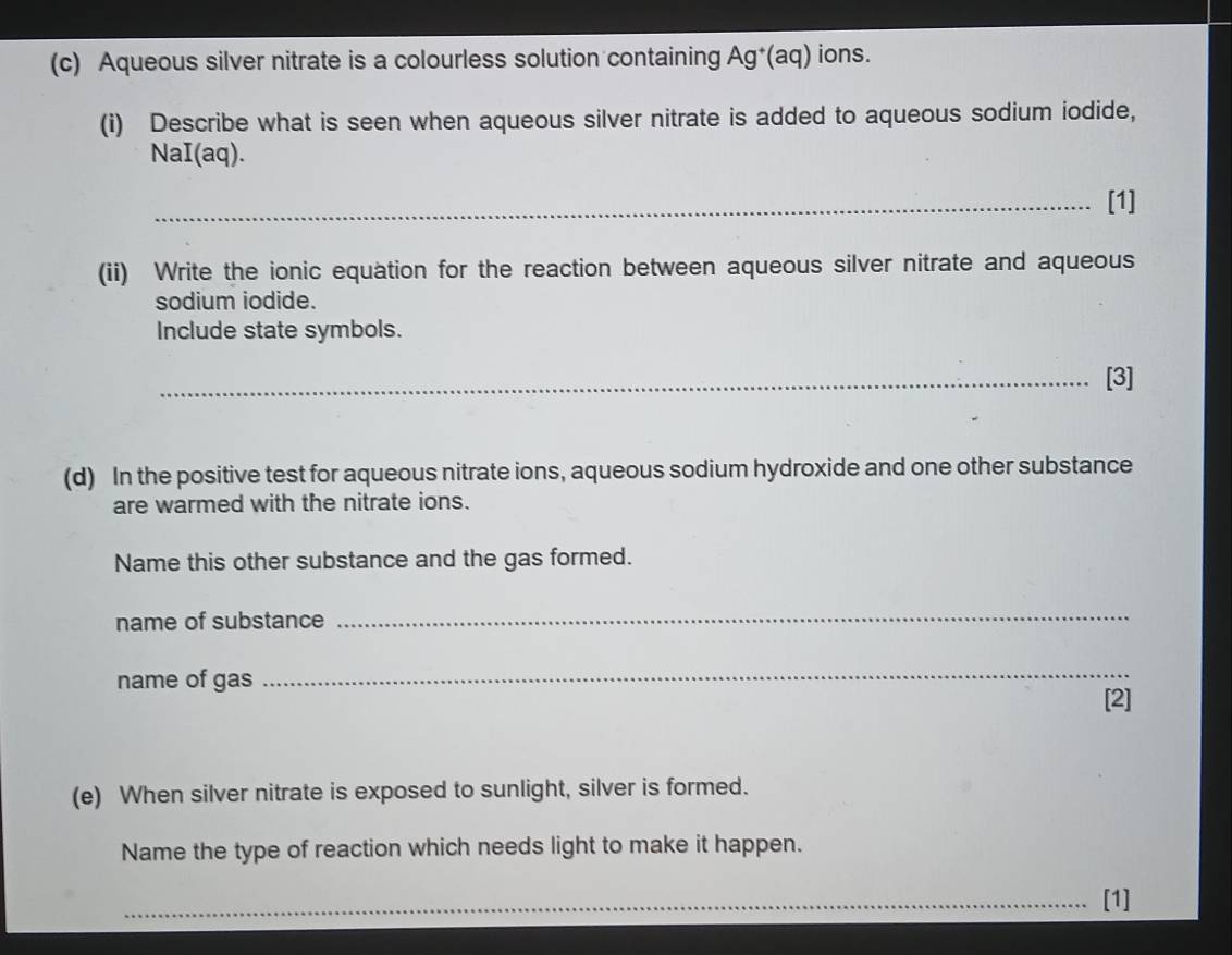 Aqueous silver nitrate is a colourless solution containing Ag*(aq) ions. 
(i) Describe what is seen when aqueous silver nitrate is added to aqueous sodium iodide, 
NaI(aq). 
_[1] 
(ii) Write the ionic equation for the reaction between aqueous silver nitrate and aqueous 
sodium iodide. 
Include state symbols. 
_[3] 
(d) In the positive test for aqueous nitrate ions, aqueous sodium hydroxide and one other substance 
are warmed with the nitrate ions. 
Name this other substance and the gas formed. 
name of substance 
_ 
name of gas 
_ 
[2] 
(e) When silver nitrate is exposed to sunlight, silver is formed. 
Name the type of reaction which needs light to make it happen. 
_[1]