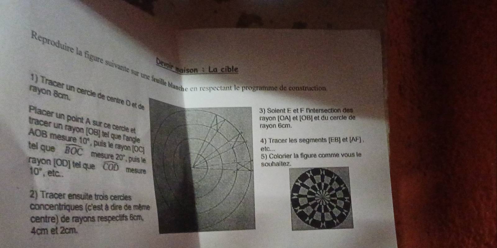 Reproduire la figure suivante sar une feuille blauche en respectant le programme de construction 
Devoir maison: La cible 
1 ) Tracer un cercle de centre O et de 
rayon 8cm. 
3) Soient E et F l'intersection des 
rayon [ OA ] et [ OB ] et du cercle de 
Placer un point A sur ce cercle et 
rayon 6cm. 
tracer un rayon [ OB ] tel que l'angle 
4) Tracer les segments [ EB ] et [ AF ] ,
AOB mesure 10° , puis le rayon [ OC) 
etc... 
tel que widehat BOC mesure 20° puis le 
5) Colorier la figure comme vous le 
souhaitez. 
rayon [ OD ] tel que widehat COD mesure
10° , etc.. 
2) Tracer ensuite trois cercles 
concentriques (c'est à dire de même 
centre) de rayons respectifs 6cm,
4cm et 2cm.