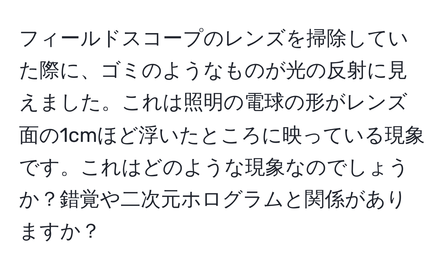 フィールドスコープのレンズを掃除していた際に、ゴミのようなものが光の反射に見えました。これは照明の電球の形がレンズ面の1cmほど浮いたところに映っている現象です。これはどのような現象なのでしょうか？錯覚や二次元ホログラムと関係がありますか？