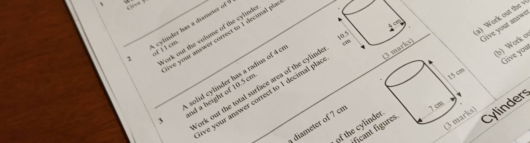 1 `N 
Cave y 
2 cylinder has a diameter of
cm 4 cm
ve your answer correct to 1 decimal pla
10.5
a) Work out the 
Give your answ 
ork out the volume of the cylind 
of 11 cm.
15 cm
solid cylinder has a radius of 4 c
(b) Work o 
ork out the total surface area of the cylind 
3 marks 
Give you 
nd a height of 10.5 cn
ve your answer correct to 1 decimal pla
7 cm
3 
(3 marks) 
diameter of 7 cn
of the cylinder 
Cylinders 
ficant figures