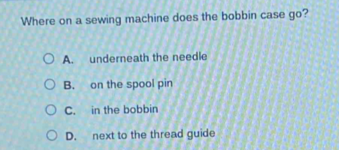 Where on a sewing machine does the bobbin case go?
A. underneath the needle
B. on the spool pin
C. in the bobbin
D. next to the thread guide