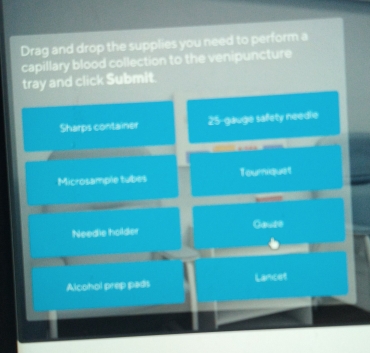 Drag and drop the supplies you need to perform a 
capillary blood collection to the venipuncture 
tray and click Submit. 
Sharps container 25 -gauge safety needle 
n 
Microsample tubes Tourniquet 
Needie holder Gause 
1 
Alcohol prep pads Lancet
