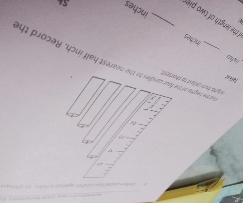 bematics Quz Book, STAAR Mathematic , 
Graham placed four candles against a ruler, as shown 
4 
in 
heights from tallest to shortest . 
Tallest 
_and the heights of the four candles to the nearest half inch. Record th
inches
inches
the length of two pie _
inches
S