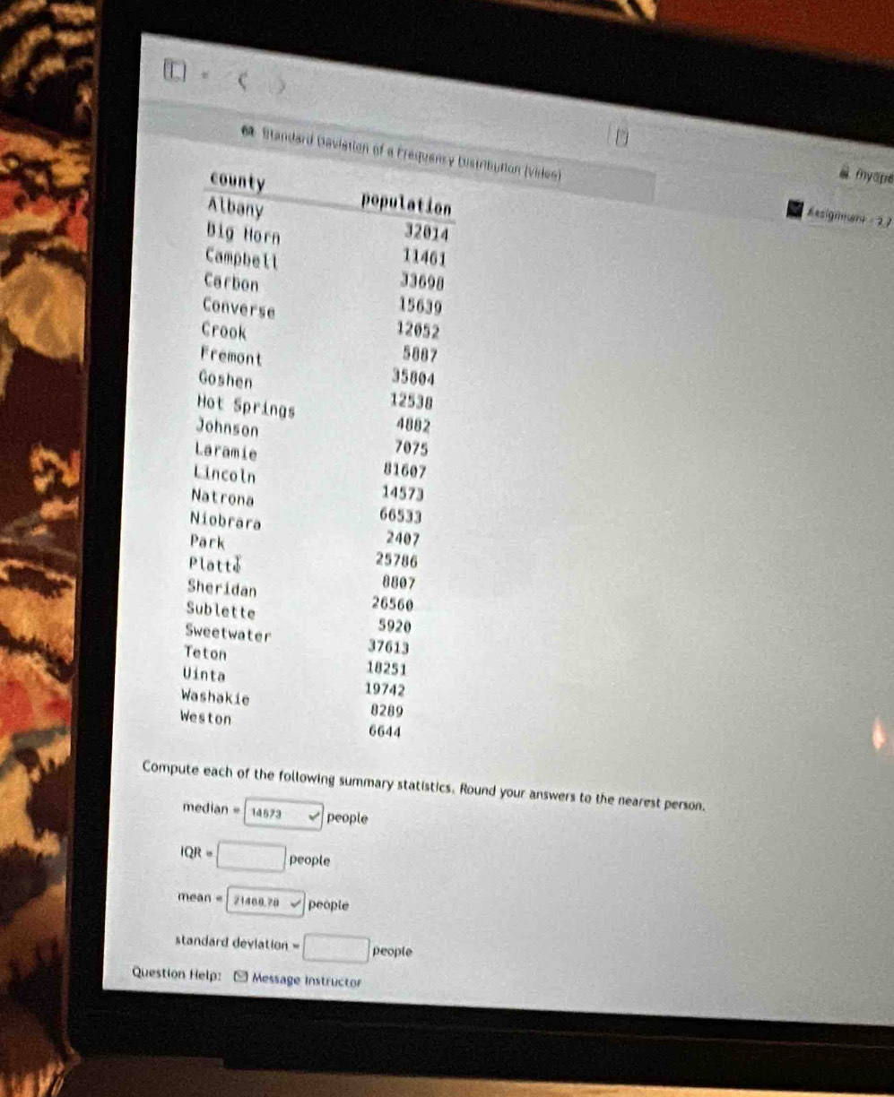 ( ) 
6 Standard Daviation Distributlon (viden) 
myope 
Resignment 2 7 
Compute each of the following summary statistics. Round your answers to the nearest person. 
median = 14673 v people
IQR = □ people
mean = 21468.78 √ people 
standard deviation =□ people 
Question Help: * Message instructor