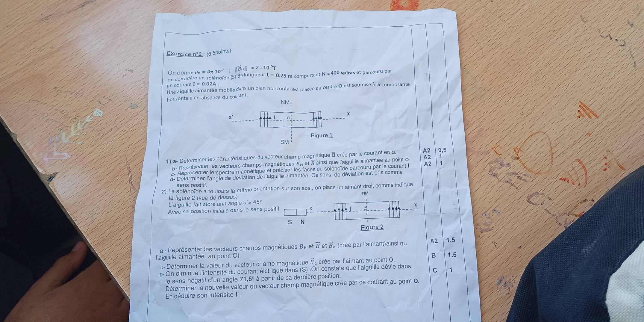 Exercice n°2 : (6,5points)
On donne μ =4π .10^(-7);||vector B_H||=2.10^(-5)T L=0.25 5 m comportant N=400 ) spires et parcouru par
on considère un solénoïde (S) de longueur
un courant I = 0.02A .
Une aiguille aimantée mobile dans un plan horizontal est placée au centre 0 est soumise à la composante
horizontale en absence du courant.
NM

x'
Figure 1
SM
1) a- Déterminer les caractéristiques du vecteur champ magnétique B crée par le courant en 0. A2 0,5
b- Représenter les vecteurs champs magnétiques BI et B ainsi que l'aiguille aimantée au point o A2
c- Représenter le spectre magnétique et préciser les faces du solénoïde parcouru par le courant le A2
d- Déterminer l'angle de déviation de l'aiguille aimantée. Ce sens de déviation est pris comme
sens positif.
2) Le solénoïde a toujours la même orientation sur son axe , on place un aimant droit comme indique
-NM
la figure 2 (vue de dessus)
L'aiguille fait alors unn angle a'=45°
Avec sa position initiale dans le sens positif
      
S N
Fiqure 2
a - Représenter les vecteurs champs magnétiques vector B_k etvector Betvector B 。 (crée par l'aimant)ainsi qu A2 1,5
l'aiguille aimantée au point O).
B 1.5
b- Déterminer la valeur du vecteur champ magnétique B, crée par l'aimant au point 0.
c- On diminue l'intensité du courant élctrique dans (S) .On constate que l'aiguille dévie dans C 1
le sens négatif d'un angle 71,6° à partir de sa dernière position.
Déterminer la nouvelle valeur du vecteur champ magnétique crée par ce courant au point 0.
En déduire son intensité I'.