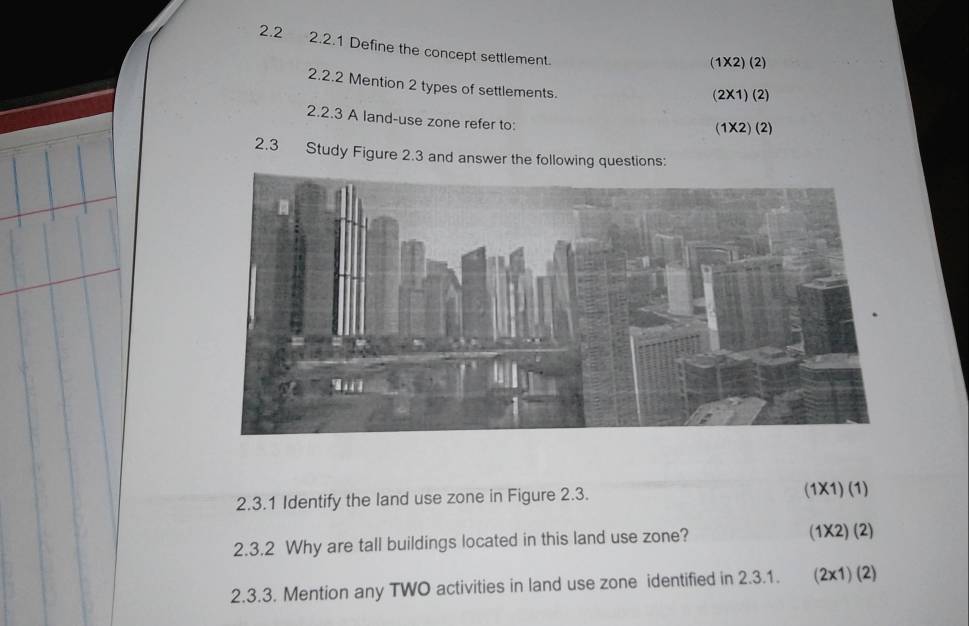 2.2 2.2.1 Define the concept settlement. 
(1X2) (2) 
2.2.2 Mention 2 types of settlements. 
(2X1) (2) 
2.2.3 A land-use zone refer to: 
(1X2) (2) 
2.3 Study Figure 2.3 and answer the following questions: 
2.3.1 Identify the land use zone in Figure 2.3. (1X1) (1) 
2.3.2 Why are tall buildings located in this land use zone? (1X2) (2) 
2.3.3. Mention any TWO activities in land use zone identified in 2.3.1. (2x1) (2)