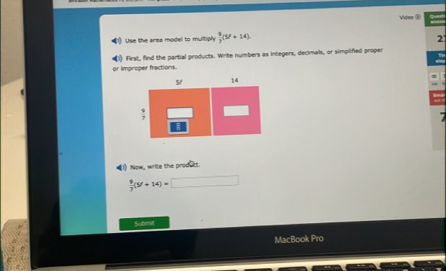 Video ③ Quest
Use the area model to multiply  9/7 (5f+14).
2
First, find the partial products. Write numbers as integers, decimals, or simplified proper
T
or improper fractions.
X
tar
put i
1) Now, write the produtt.
 9/7 (5f+14)=
Submit
MacBook Pro