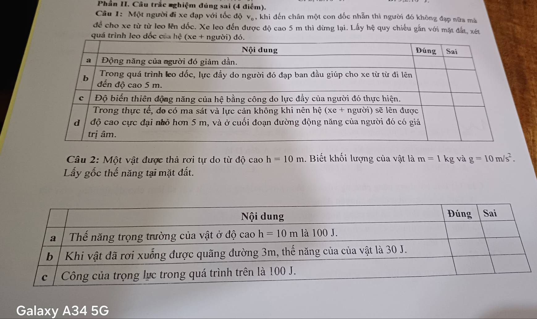 Phần II. Câu trắc nghiệm đúng sai (4 điểm).
Câu 1: Một người đi xe đạp với tốc độ V_0 , khi đến chân một con dốc nhẵn thì người đó không đạp nữa mà
để cho xe từ từ leo lên dốc. Xe leo đến được độ cao 5 m thì dừng lại. Lấy hệ quy chiếu gắn với mặt đất, xét
quá trì
Câu 2: Một vật được thả rơi tự do từ độ caoh=10m 1. Biết khối lượng của vật là m=1 kg và g=10m/s^2.
Lấy gốc thế năng tại mặt đất.
Galaxy A34 5G