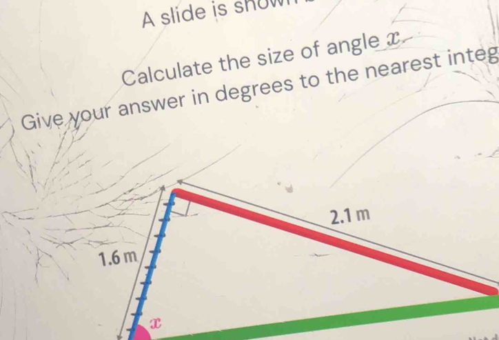 A slide is show 
Calculate the size of angle x
Give your answer in degrees to the nearest integ