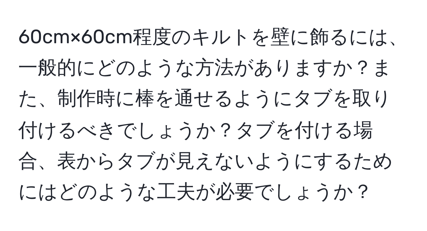 60cm×60cm程度のキルトを壁に飾るには、一般的にどのような方法がありますか？また、制作時に棒を通せるようにタブを取り付けるべきでしょうか？タブを付ける場合、表からタブが見えないようにするためにはどのような工夫が必要でしょうか？