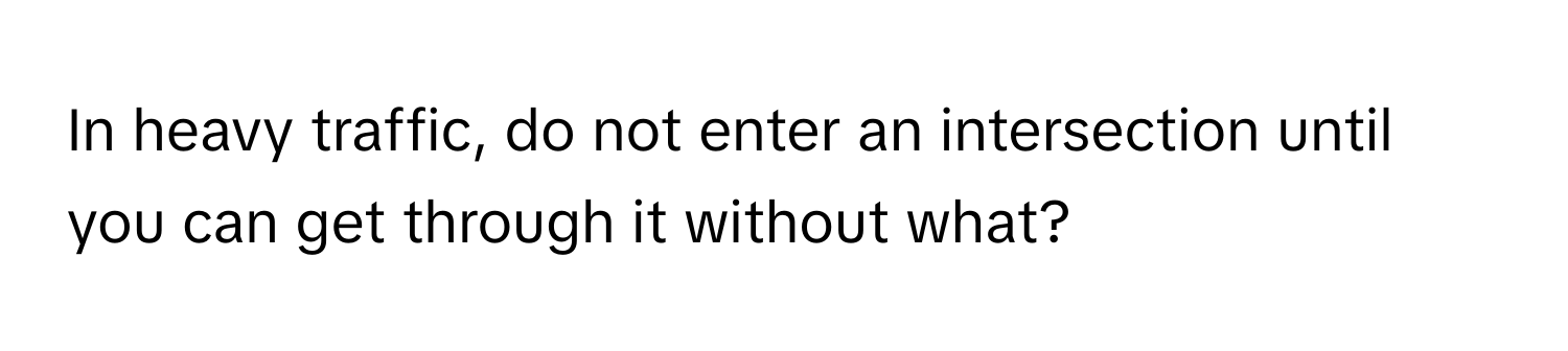 In heavy traffic, do not enter an intersection until you can get through it without what?