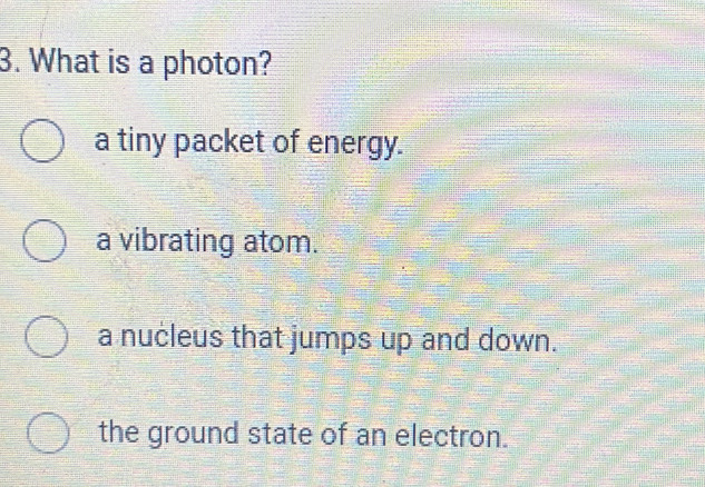 What is a photon?
a tiny packet of energy.
a vibrating atom.
a nucleus that jumps up and down.
the ground state of an electron.