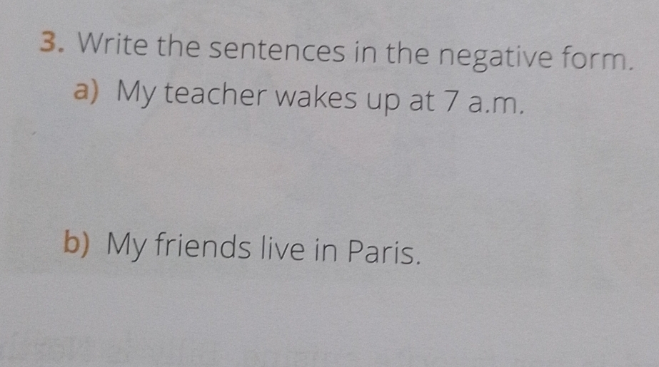 Write the sentences in the negative form. 
a) My teacher wakes up at 7 a.m. 
b) My friends live in Paris.