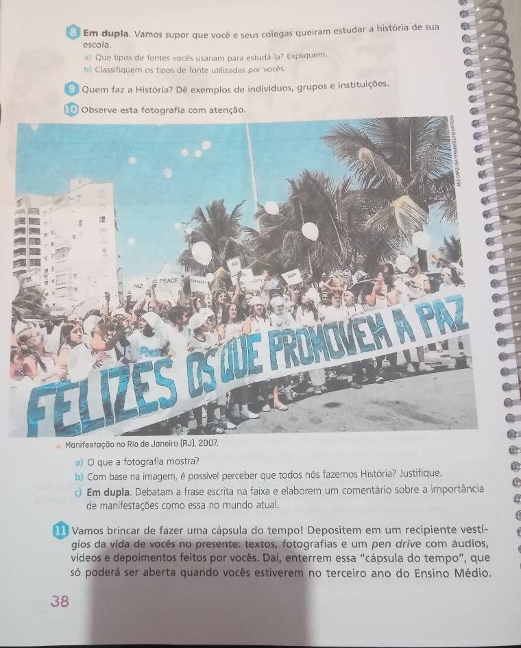 Em dupla. Vamos supor que você e seus colegas queiram estudar a história de sua 
escola. 
a) Que tipos de fontes vocês usariam para estudá-la? Expliquem. 
b) Classifiquem os tipos de fonte utilizadas por vocês 
Quem faz a História? Dê exemplos de indivíduos, grupos e instituições. 
Observe esta fotografia com atenção. 
Manif 
a) O que a fotografia mostra? 
b) Com base na imagem, é possível perceber que todos nós fazemos História? Justifique. 
c) Em dupla. Debatam a frase escrita na faixa e elaborem um comentário sobre a importância 
de manifestações como essa no mundo atual. 
11 Vamos brincar de fazer uma cápsula do tempo! Depositem em um recipiente vestí- 
gios da vida de vocês no presente: textos, fotografias e um pen dríve com áudios, 
vídeos e depoimentos feitos por vocês. Daí, enterrem essa “cápsula do tempo", que 
só poderá ser aberta quando vocês estiverem no terceiro ano do Ensino Médio. 
38