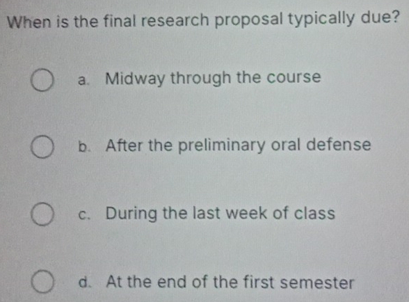 When is the final research proposal typically due?
a. Midway through the course
b. After the preliminary oral defense
c. During the last week of class
d. At the end of the first semester