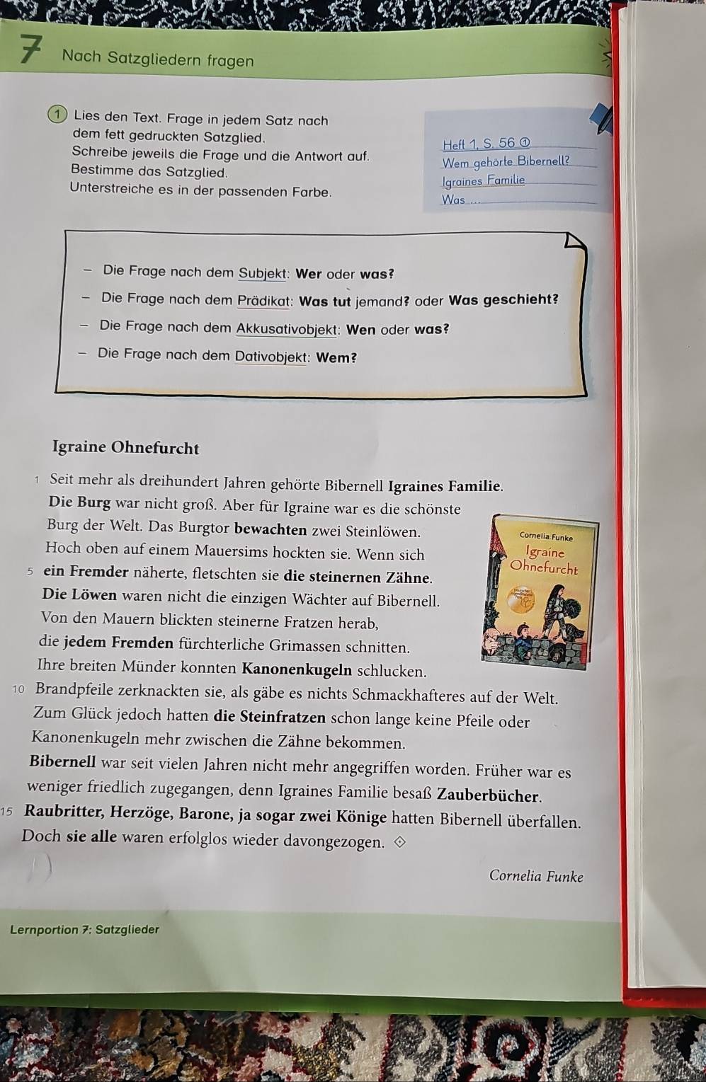 Nach Satzgliedern fragen
1 Lies den Text. Frage in jedem Satz nach
dem fett gedruckten Satzglied.
Hefl 1. S. 56 ①
Schreibe jeweils die Frage und die Antwort auf.
Bestimme das Satzglied.
Wem gehörte Bibernell?
Igraines Familie
Unterstreiche es in der passenden Farbe.
Was_
Die Frage nach dem Subjekt: Wer oder was?
Die Frage nach dem Prädikat: Was tut jemand? oder Was geschieht?
Die Frage nach dem Akkusativobjekt: Wen oder was?
Die Frage nach dem Dativobjekt: Wem?
Igraine Ohnefurcht
1 Seit mehr als dreihundert Jahren gehörte Bibernell Igraines Familie.
Die Burg war nicht groß. Aber für Igraine war es die schönste
Burg der Welt. Das Burgtor bewachten zwei Steinlöwen.
Hoch oben auf einem Mauersims hockten sie. Wenn sich 
5 ein Fremder näherte, fletschten sie die steinernen Zähne.
Die Löwen waren nicht die einzigen Wächter auf Bibernell.
Von den Mauern blickten steinerne Fratzen herab,
die jedem Fremden fürchterliche Grimassen schnitten.
Ihre breiten Münder konnten Kanonenkugeln schlucken.
10 Brandpfeile zerknackten sie, als gäbe es nichts Schmackhafteres auf der Welt.
Zum Glück jedoch hatten die Steinfratzen schon lange keine Pfeile oder
Kanonenkugeln mehr zwischen die Zähne bekommen.
Bibernell war seit vielen Jahren nicht mehr angegriffen worden. Früher war es
weniger friedlich zugegangen, denn Igraines Familie besaß Zauberbücher.
15 Raubritter, Herzöge, Barone, ja sogar zwei Könige hatten Bibernell überfallen.
Doch sie alle waren erfolglos wieder davongezogen.
Cornelia Funke
Lernportion 7: Satzglieder