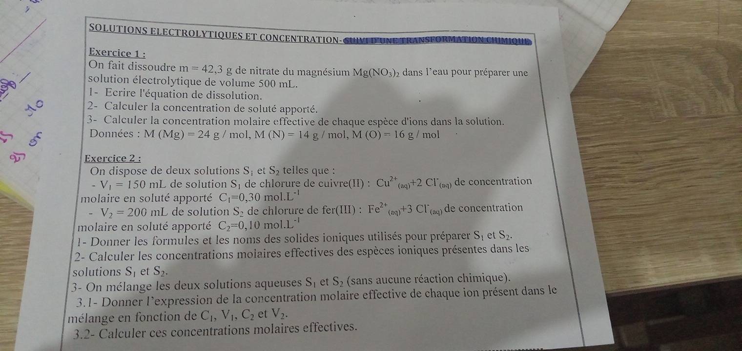 SOLUTIONS ELECTROLYTIQUES ET CONCENTRATION-CUVI D'UNE   RANSFORMATION CHIMIOUE
Exercice 1 :
On fait dissoudre m=42,3 g de nitrate du magnésium Mg(NO_3)_2 2 dans l'eau pour préparer une
solution électrolytique de volume 500 mL.
1- Ecrire l'équation de dissolution.
AC 2- Calculer la concentration de soluté apporté.
3- Calculer la concentration molaire effective de chaque espèce d'ions dans la solution.
Données : M(Mg)=24g/mol,M(N)=14g/mol, M(O)=16g/ mol
D Exercice 2 :
On dispose de deux solutions S_i et S_2 telles que :
-V_1=150mL de solution S_1 de chlorure de cuivre(II) : Cu^(2+)_(aq)+2Cl^-_(aq) de concentration
molaire en soluté apporté C_1=0,30mol.L^(-1)
V_2=200mL de solution S_2 de chlorure de fer(III ): Fe^(2+)_(aq)+3Cl^-_(aq) de concentration
molaire en soluté apporté C_2=0,10mol· L^(-1)
1- Donner les formules et les noms des solides ioniques utilisés pour préparer S_1 et S_2.
2- Calculer les concentrations molaires effectives des espèces ioniques présentes dans les
solutions S_1 et S_2.
3- On mélange les deux solutions aqueuses S_1 et S_2 (sans aucune réaction chimique).
3.1- Donner l'expression de la concentration molaire effective de chaque ion présent dans le
mélange en fonction de C_1,V_1,C_2 et V_2.
3.2- Calculer ces concentrations molaires effectives.