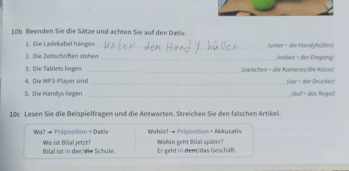 10b Beenden Sie die Sätze und achten Sie auf den Dativ. 
1. Die Ladekabel hängen _(unter - die Handyhüllen) 
2. Die Zeitschriften stehen _(neben • der Eingang) 
3. Die Tablets liegen _(zwischen • die Kameras/die Kasse) 
4. Die MP3-Player sind _(vor • der Drucker) 
5. Die Handys liegen _(auf • das Regal) 
10c Lesen Sie die Beispielfragen und die Antworten. Streichen Sie den falschen Artikel. 
Wo? → Präposition + Dativ Wohin? → Präposition + Akkusativ 
Wo ist Bilal jetzt? Wohin geht Bilal später? 
Bilal ist in der/die Schule. Er geht in dem/das Geschäft.