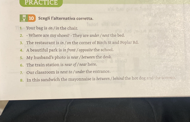 PRACTICE 
10 Scegli l’alternativa corretta. 
1. Your bag is on / in the chair. 
2. - Where are my shoes? - They are under / next the bed. 
3. The restaurant is in /on the corner of Birch St and Poplar Rd. 
4. A beautiful park is in front / opposite the school. 
5. My husband’s photo is near / between the desk. 
6. The train station is near of / near here. 
7. Our classroom is next to / under the entrance. 
8. In this sandwich the mayonnaise is between / behind the hot dog and the tomato.