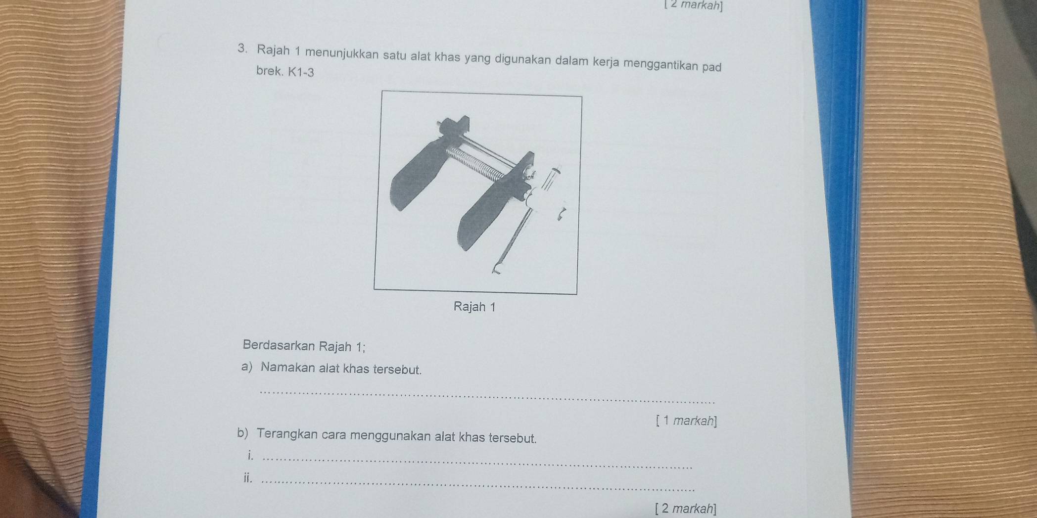 [ 2 markah] 
3. Rajah 1 menunjukkan satu alat khas yang digunakan dalam kerja menggantikan pad 
brek. K1-3
Berdasarkan Rajah 1; 
a) Namakan alat khas tersebut. 
_ 
[ 1 markah] 
b) Terangkan cara menggunakan alat khas tersebut. 
i._ 
ⅱ._ 
[ 2 markah]