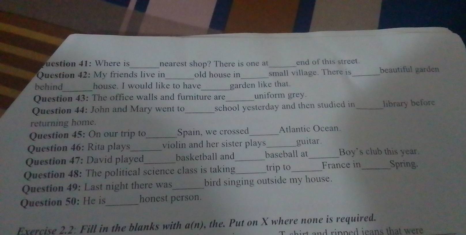 uestion 41: Where is _nearest shop? There is one at _end of this street. 
Question 42: My friends live in_ old house in_ small village. There is_ beautiful garden 
behind_ house. I would like to have_ garden like that. 
Question 43: The office walls and furniture are_ uniform grey. 
Question 44: John and Mary went to_ school yesterday and then studied in _library before 
returning home. 
Question 45: On our trip to_ Spain, we crossed_ Atlantic Ocean. 
Question 46: Rita plays_ violin and her sister plays_ guitar. 
Question 47: David played basketball and_ baseball at_ 
Boy's club this year. 
Question 48: The political science class is taking_ trip to_ France in_ Spring. 
Question 49: Last night there was_ bird singing outside my house. 
Question 50: He is_ honest person. 
Exercise 2.2: Fill in the blanks with a(n) , the. Put on X where none is required. 
and ripped jeans that wer .